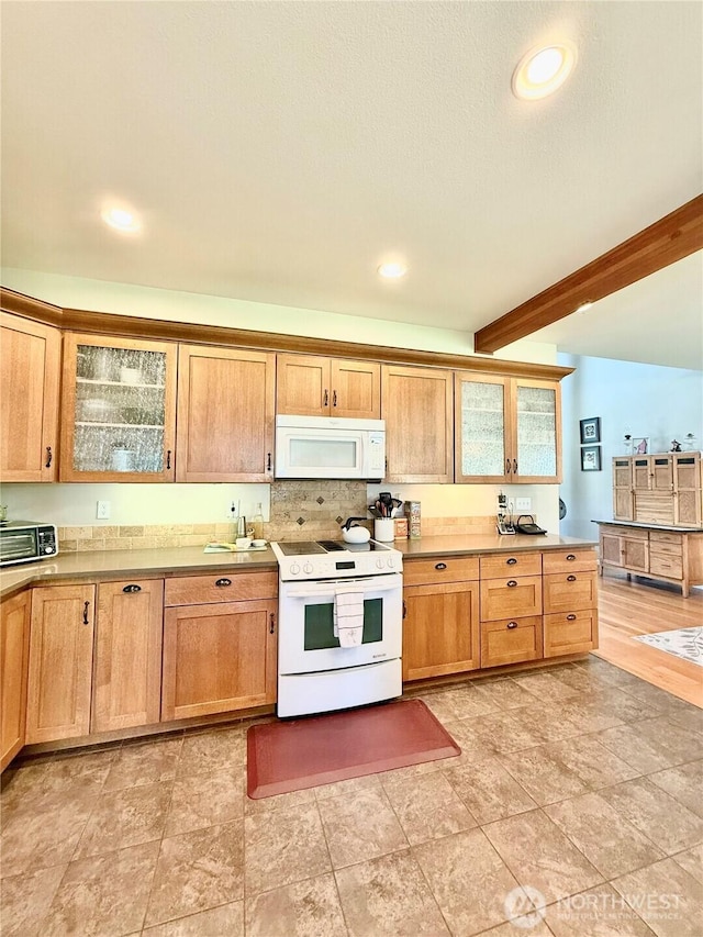 kitchen featuring beam ceiling, white appliances, glass insert cabinets, light countertops, and tasteful backsplash