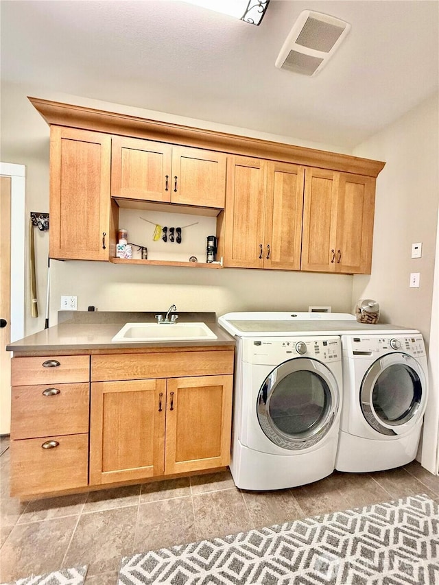 clothes washing area featuring a sink, independent washer and dryer, cabinet space, and visible vents