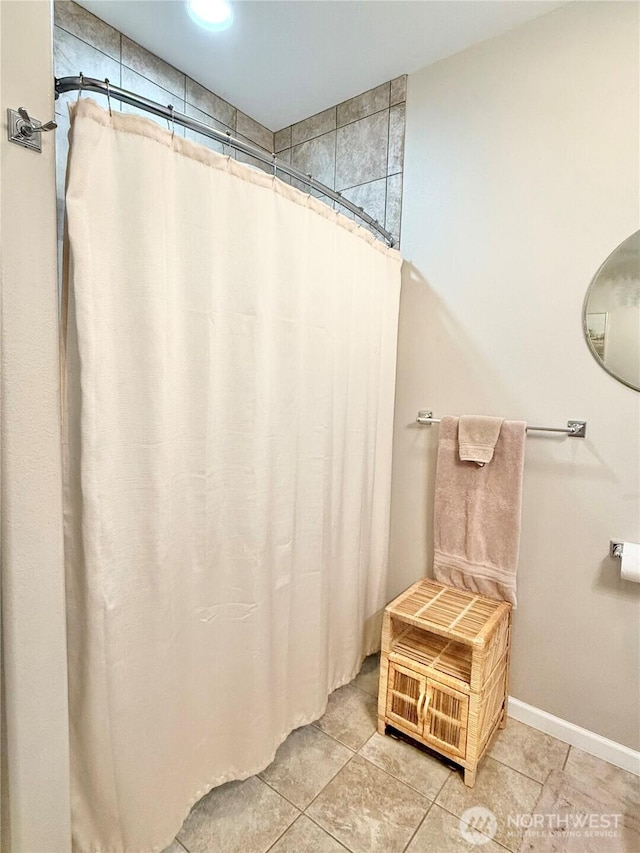 bathroom with baseboards, tile patterned flooring, and a shower with shower curtain
