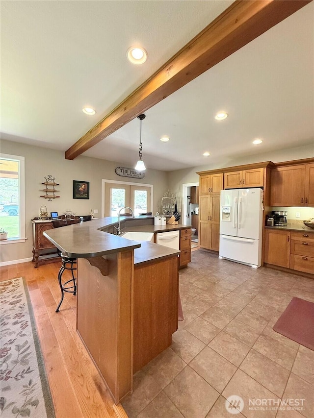 kitchen with recessed lighting, dark countertops, white appliances, and beam ceiling
