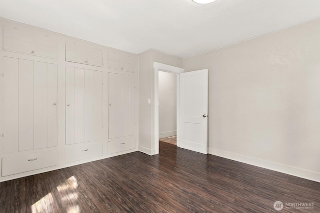 unfurnished bedroom with wood finished floors, baseboards, and a closet