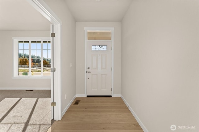 doorway to outside with visible vents, light wood-style flooring, and baseboards