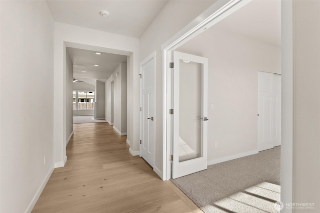 hallway featuring recessed lighting, baseboards, and light wood-style floors
