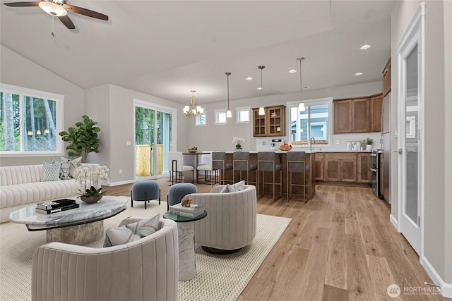 living area featuring recessed lighting, baseboards, light wood finished floors, and ceiling fan with notable chandelier
