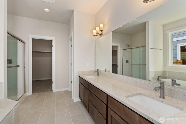 full bathroom with a sink, a stall shower, and a spacious closet