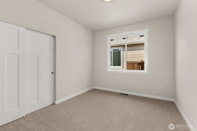 carpeted empty room with baseboards and visible vents