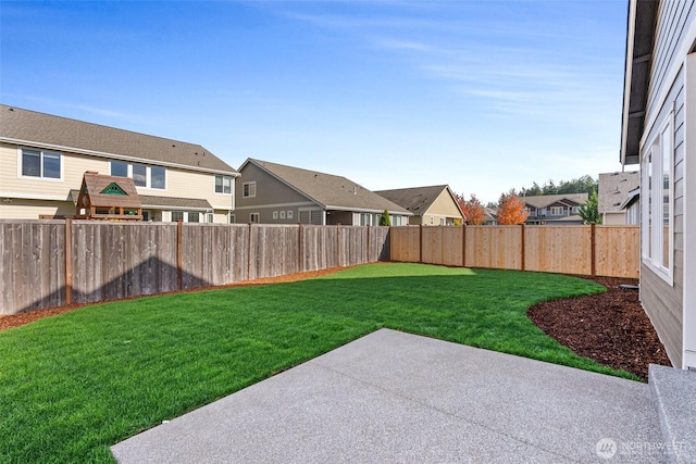 view of yard featuring a residential view, a patio, and a fenced backyard