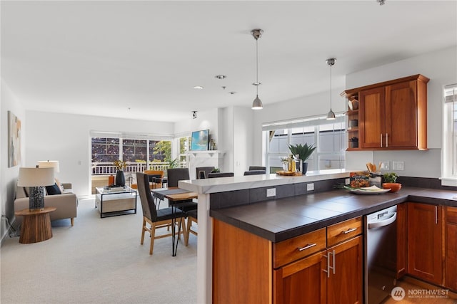 kitchen featuring pendant lighting, stainless steel dishwasher, brown cabinets, and open floor plan