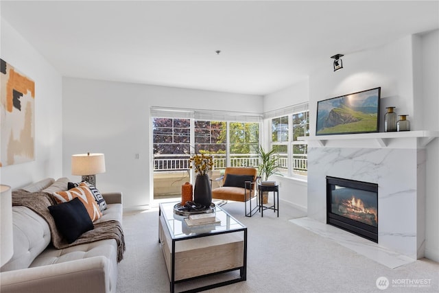 carpeted living area with baseboards and a fireplace