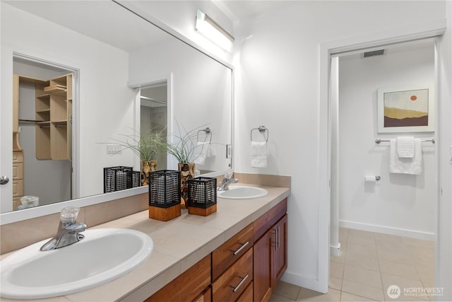 full bath with tile patterned flooring, a sink, baseboards, and visible vents