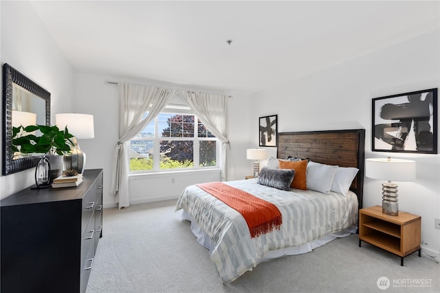 bedroom with baseboards and light colored carpet