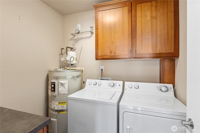 clothes washing area featuring cabinet space, independent washer and dryer, and water heater