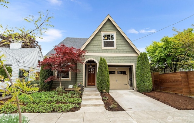 view of front of home with fence, concrete driveway, and a garage