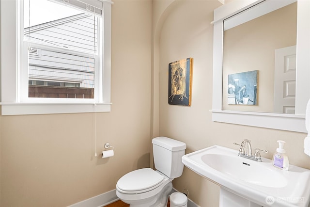 bathroom featuring baseboards, a sink, and toilet