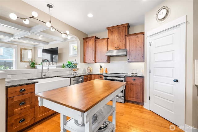 kitchen featuring a sink, appliances with stainless steel finishes, under cabinet range hood, and brown cabinets