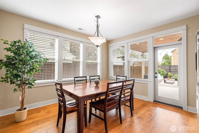 dining room with baseboards, light wood-type flooring, and visible vents