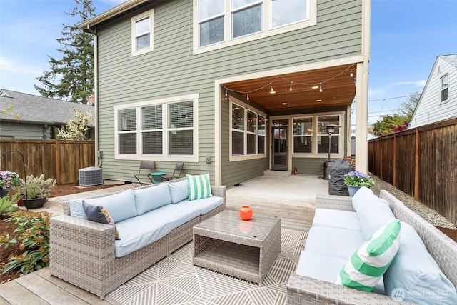 rear view of property with central air condition unit, an outdoor hangout area, and a fenced backyard