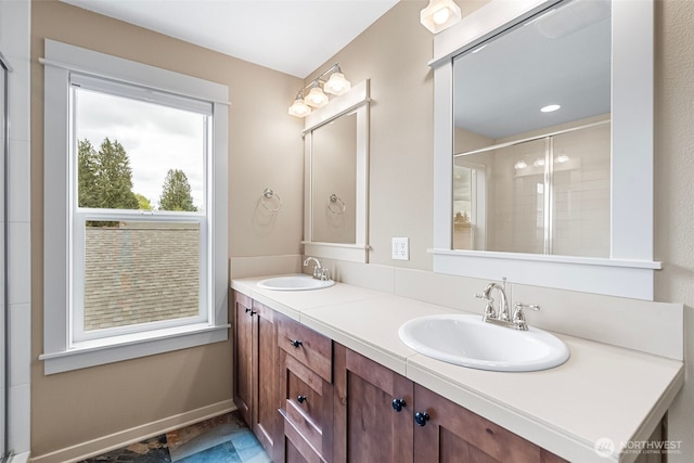 bathroom featuring double vanity, a sink, and a tile shower