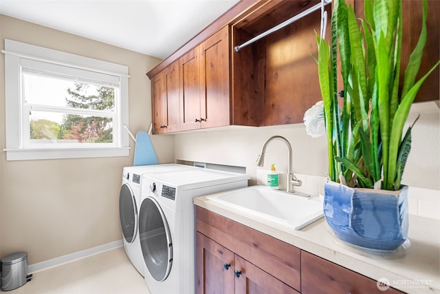 laundry room featuring a sink, baseboards, cabinet space, and washer and dryer