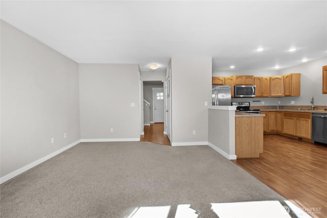 kitchen with stainless steel appliances, baseboards, light countertops, recessed lighting, and a sink
