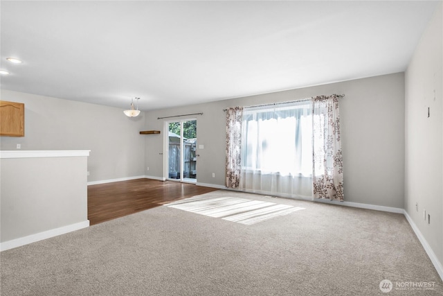 carpeted spare room with baseboards