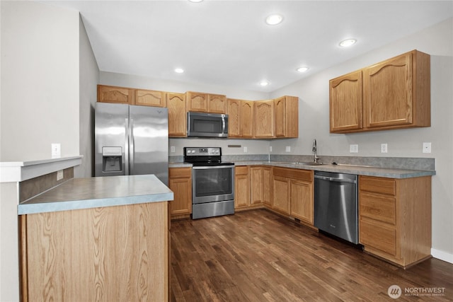 kitchen featuring stainless steel appliances, a sink, dark wood-style floors, recessed lighting, and light countertops