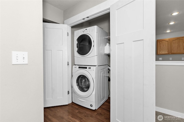 washroom with stacked washer / dryer, dark wood finished floors, and recessed lighting