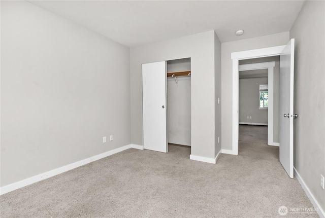 unfurnished bedroom with carpet flooring, baseboards, and a closet