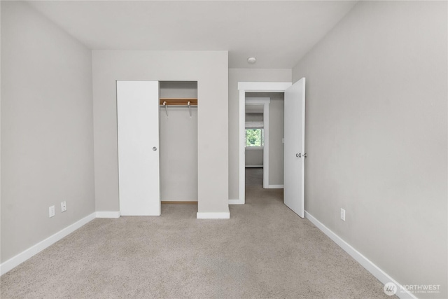 unfurnished bedroom with carpet floors, baseboards, and a closet
