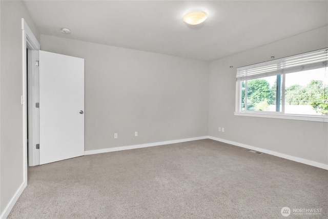 unfurnished room with carpet floors, a smoke detector, and baseboards