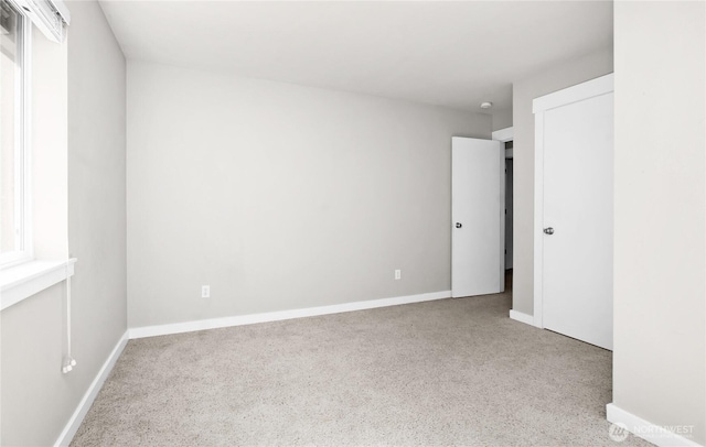 carpeted empty room featuring baseboards
