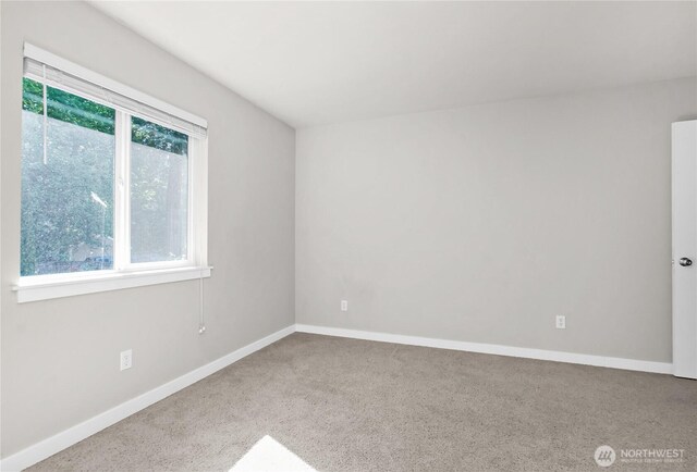 carpeted spare room with baseboards