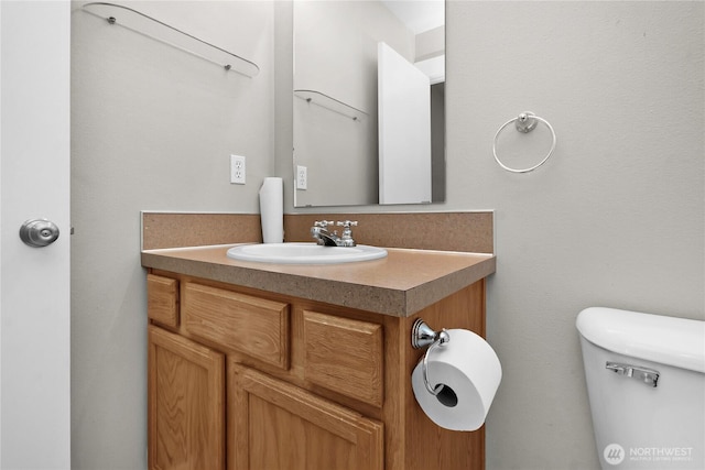 half bath featuring toilet and vanity