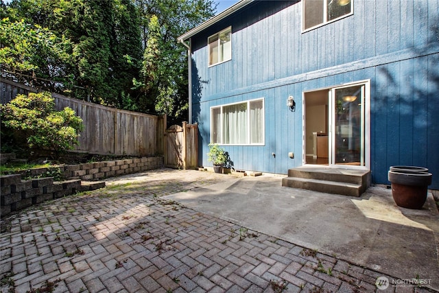 rear view of property with fence and a patio area