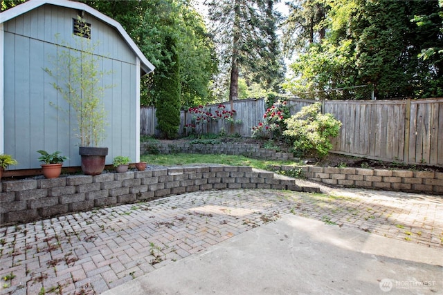 view of patio / terrace featuring a fenced backyard, an outbuilding, and a shed