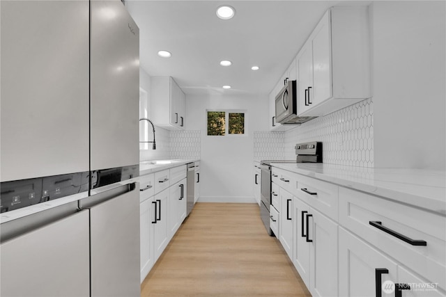 9624 SW Gorsuch Rd, Vashon, WA 98070 - kitchen with stainless steel appliances, a sink, recessed lighting, light stone counters, and tasteful backsplash