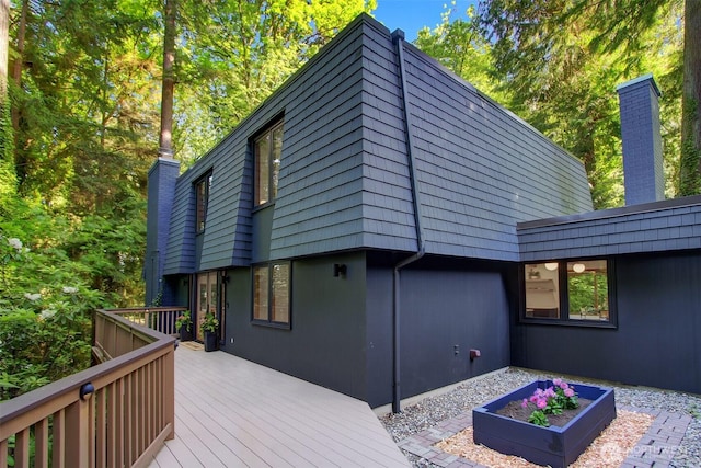 rear view of property featuring a deck and a chimney