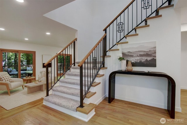 stairway with wood finished floors, recessed lighting, and baseboards