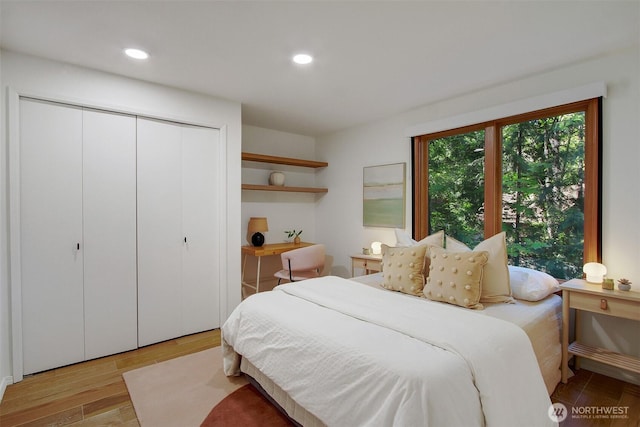 bedroom with wood finished floors, a closet, and recessed lighting