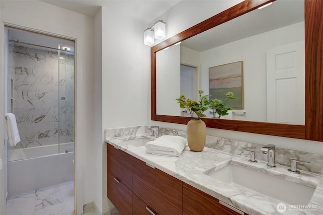 full bath with marble look tiles, double vanity, and bathing tub / shower combination