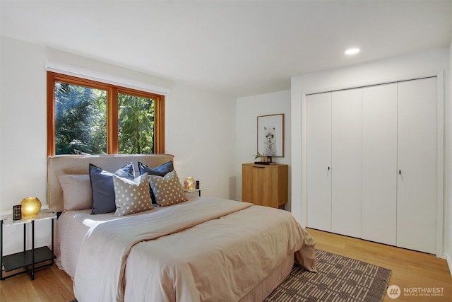 bedroom featuring light wood-type flooring, a closet, and recessed lighting