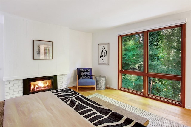 bedroom with wood finished floors and a brick fireplace