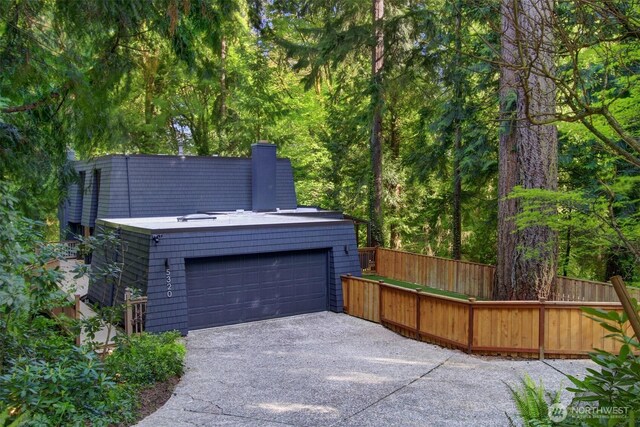 garage featuring fence and driveway