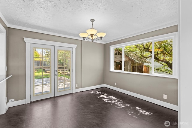 unfurnished dining area featuring ornamental molding, an inviting chandelier, a wealth of natural light, and french doors