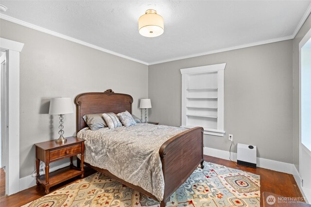 bedroom featuring crown molding, baseboards, and wood finished floors