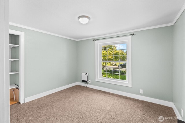 carpeted empty room featuring baseboards, heating unit, and ornamental molding