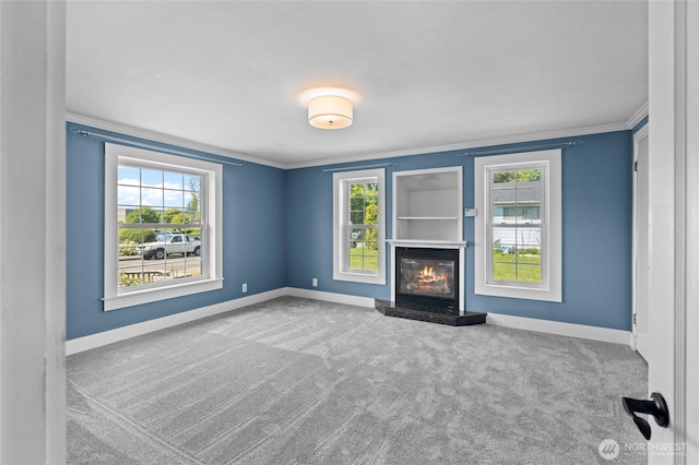 unfurnished living room with baseboards, carpet flooring, and a healthy amount of sunlight