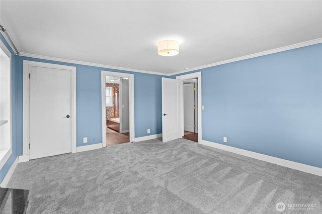 unfurnished bedroom with crown molding, connected bathroom, baseboards, and carpet floors