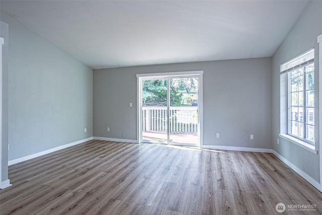 unfurnished room with baseboards and wood finished floors