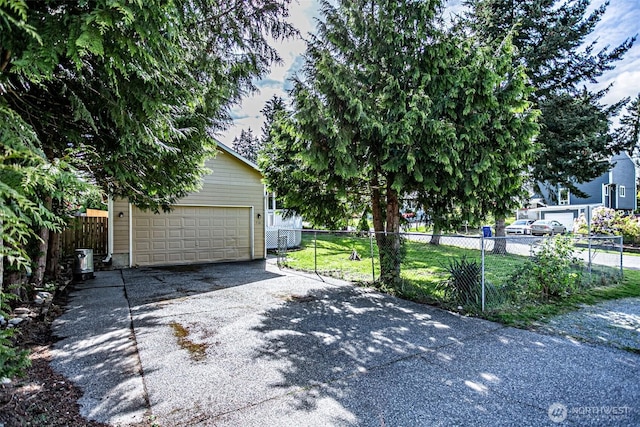 exterior space with fence, a yard, and a garage